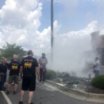 Bystanders and firefighters fire a mulch fire
